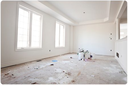 Witte kamer met verlaagd plafond, hoge ramen en verse muren, tijdens de afbouw